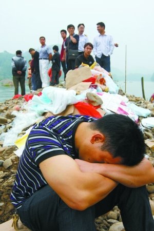 失踪人员的亲属正在现场等待消息。9日,湖南邵阳县塘田市镇一渡口发生沉船事故,救援指挥部称船上共50人,38人获救,11人死亡,另有1人失踪。目前当地已为每名死者家属预付5万元补偿金。郭国权 摄